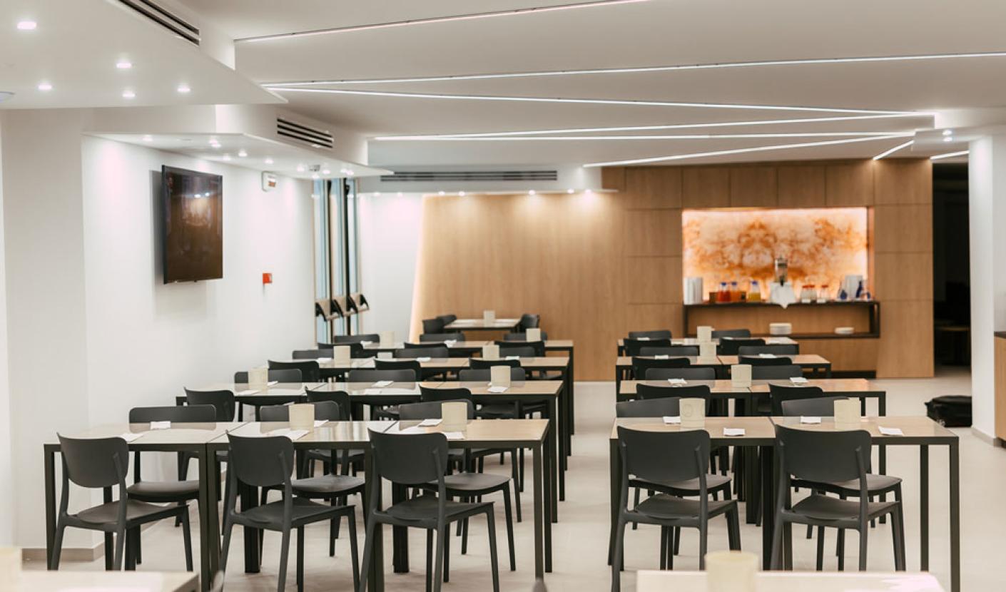 Sala da pranzo moderna con tavoli neri e illuminazione soffusa.