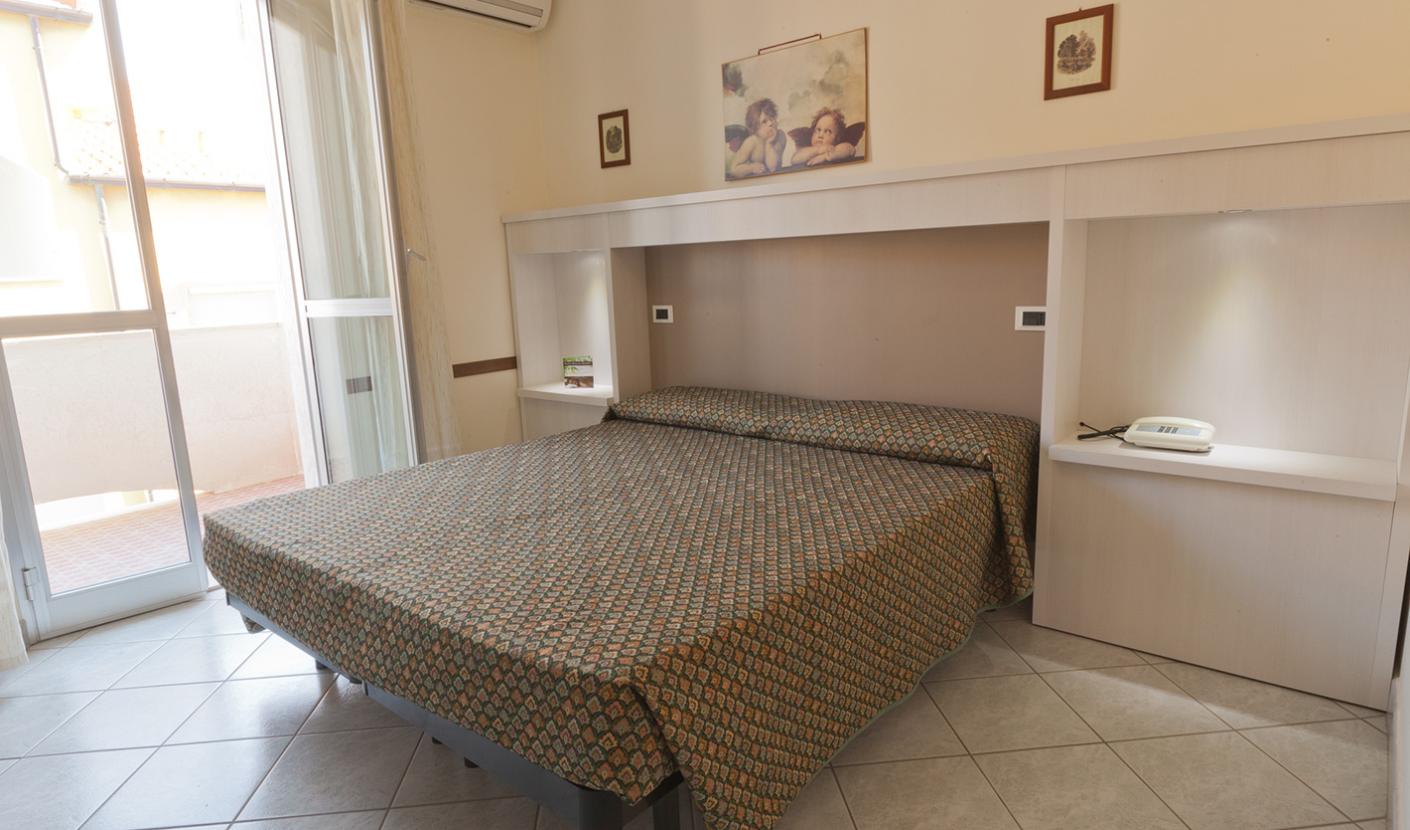 Bright bedroom with a double bed and a balcony.
