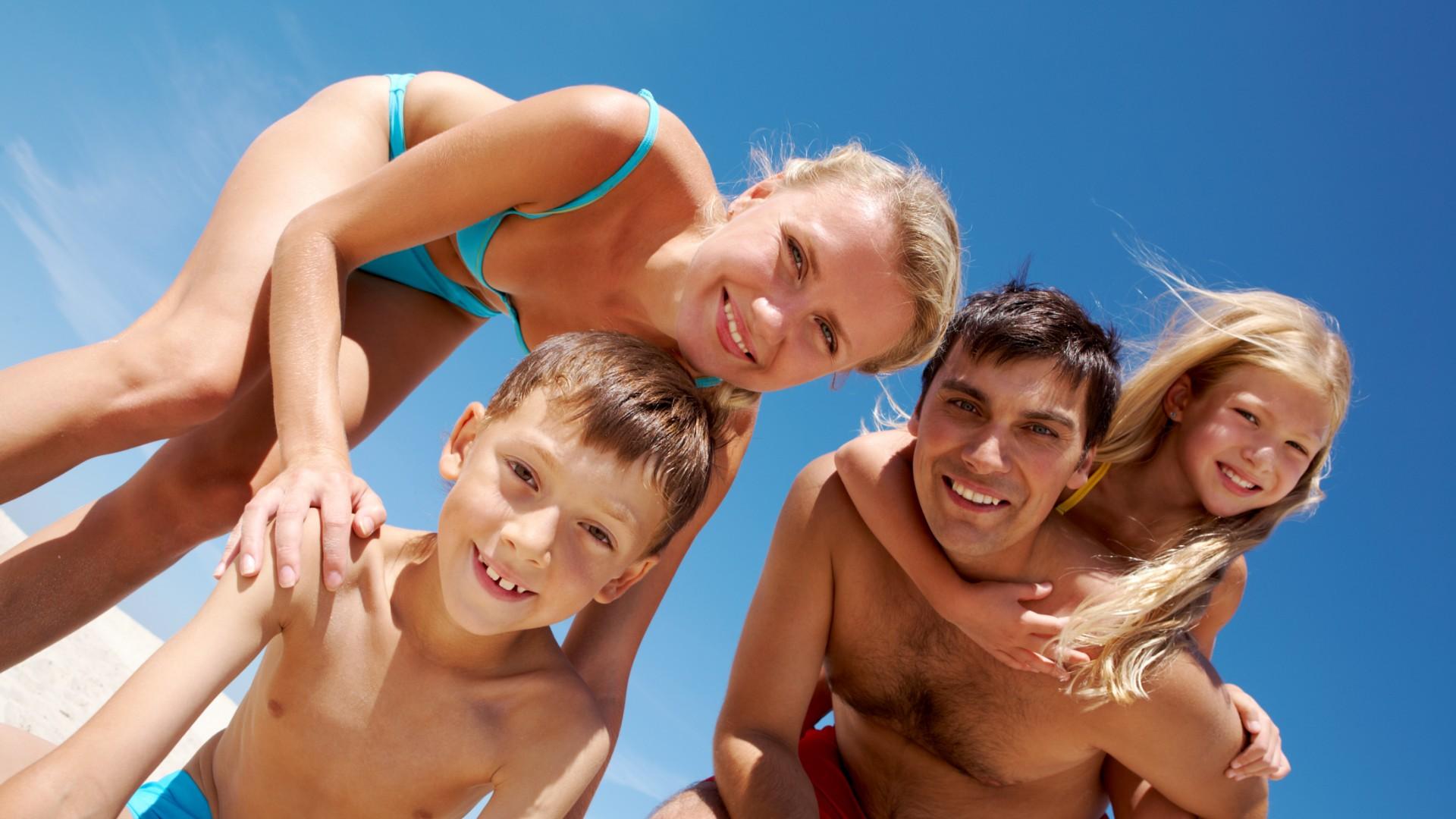 Happy family at the beach with blue sky.