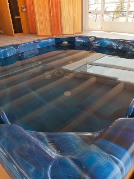 Vasca idromassaggio in un'area relax interna, con luce naturale.