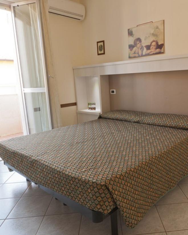 Camera da letto semplice con letto matrimoniale e aria condizionata.