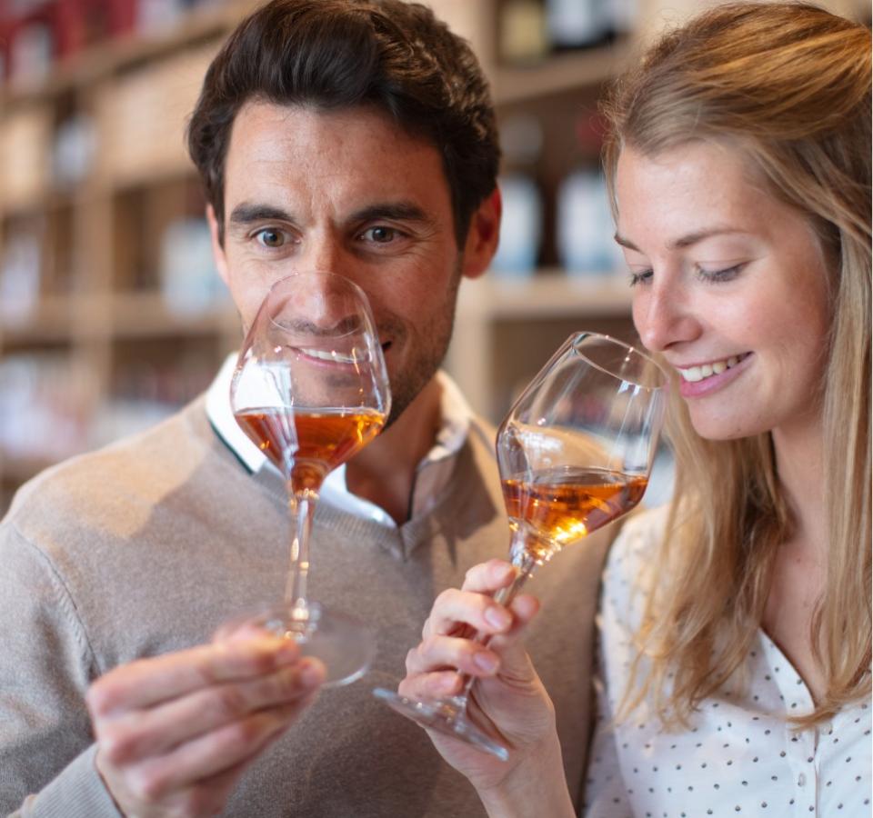 Two people tasting rosé wine in a winery.